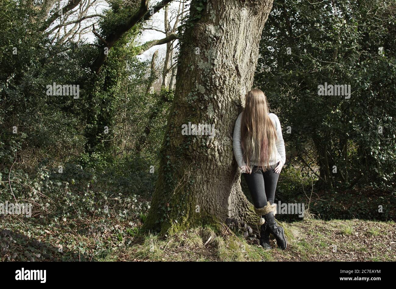 Woman Posing on the Ground Near Tree Trunk · Free Stock Photo