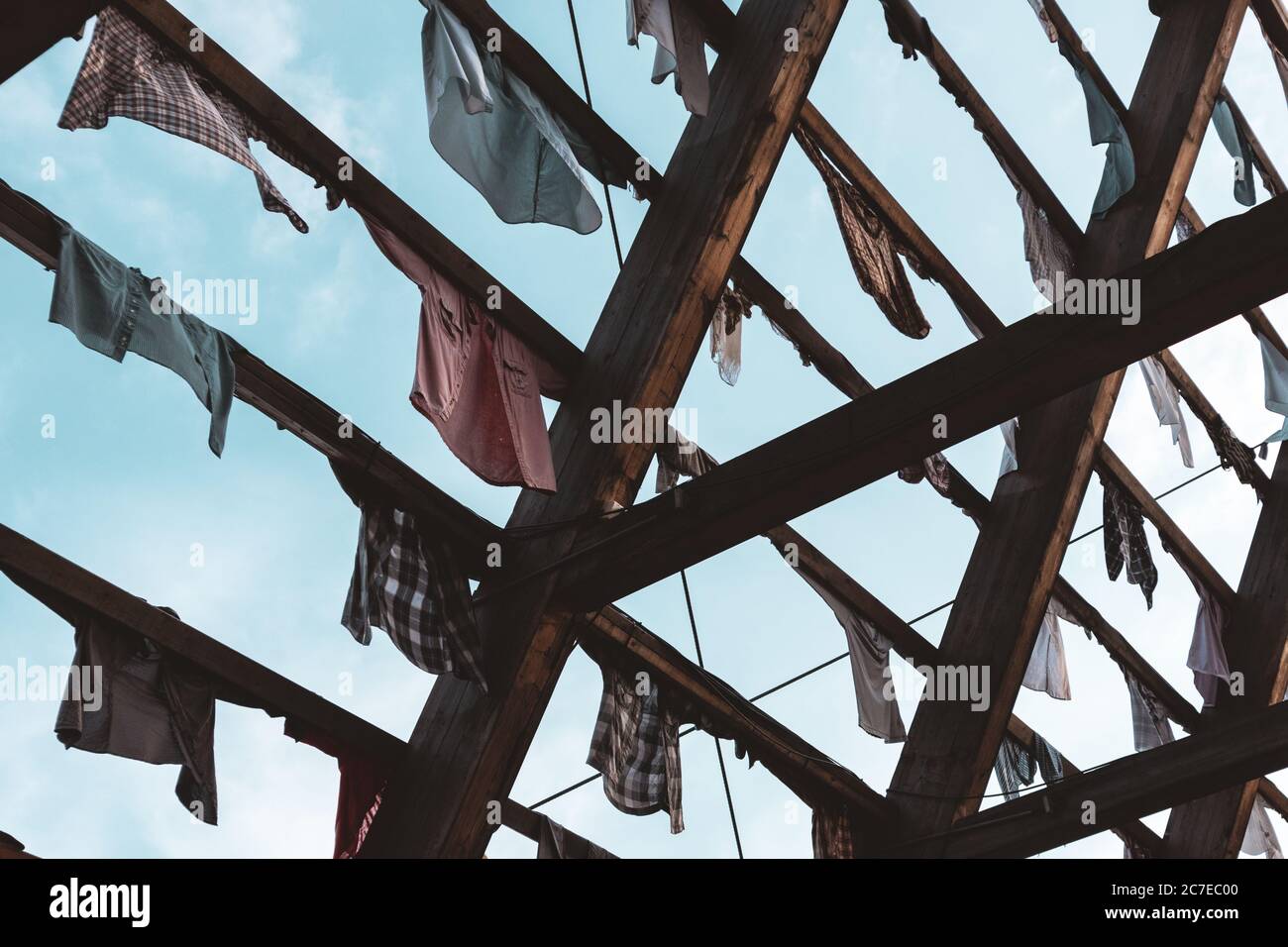 Art installation of colorful shirts clothes hanging on wooden ramp on blue sky background in Oslo, Norway Stock Photo