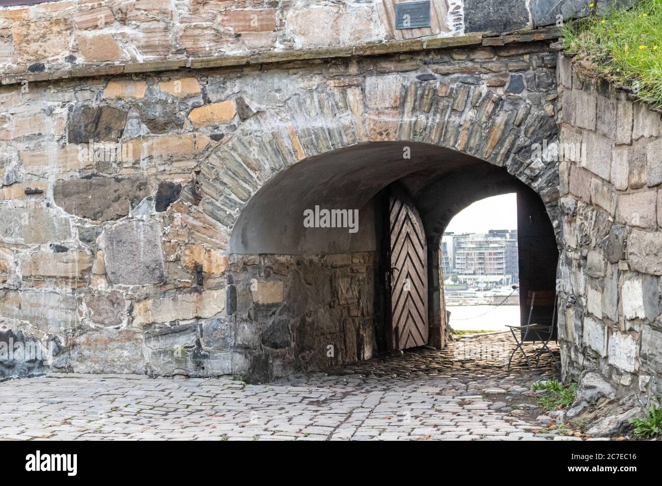 View on Oslo city through old gates of Akershus Fortress in Oslo, Norway. European fort structure landmark Stock Photo