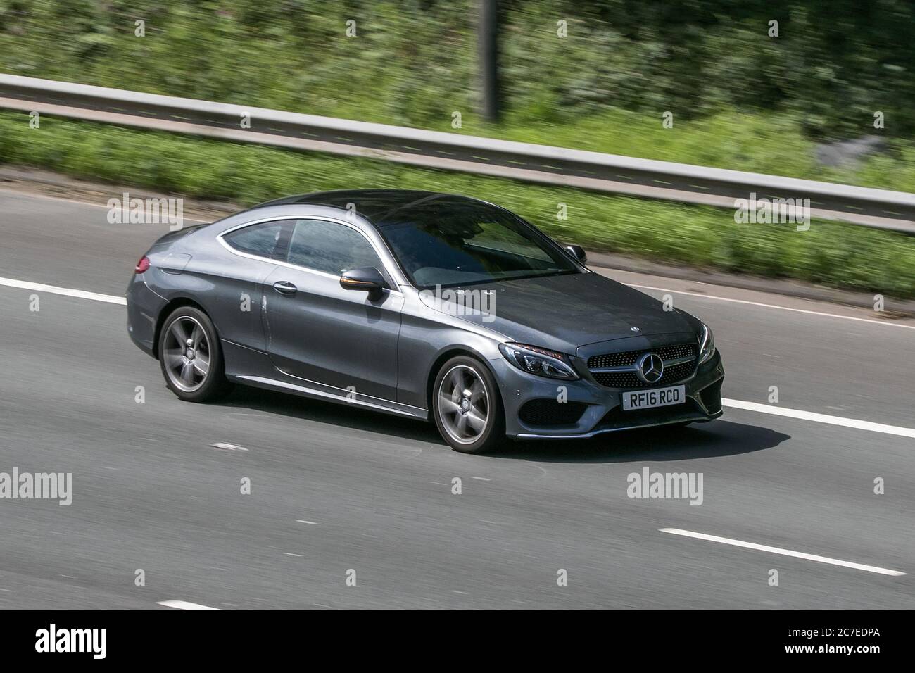 A 2016 Mercedes-Benz C 220 Amg Line Grey Car Coupe Diesel driving on the M6 motorway near Preston in Lancashire, UK Stock Photo