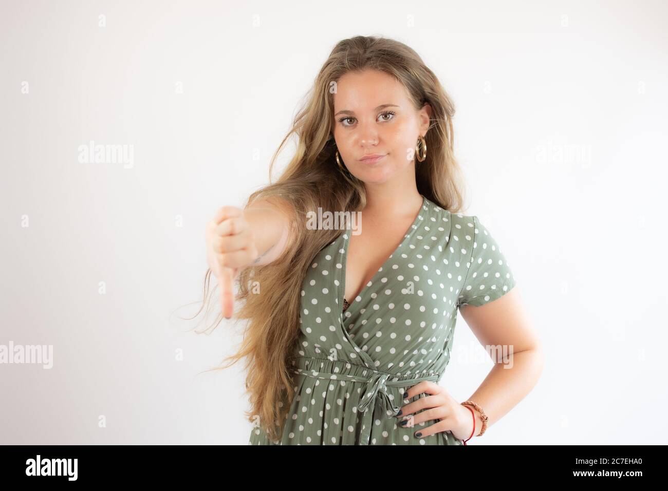 Pretty blonde girl in a green dress making finger down gesture Stock ...
