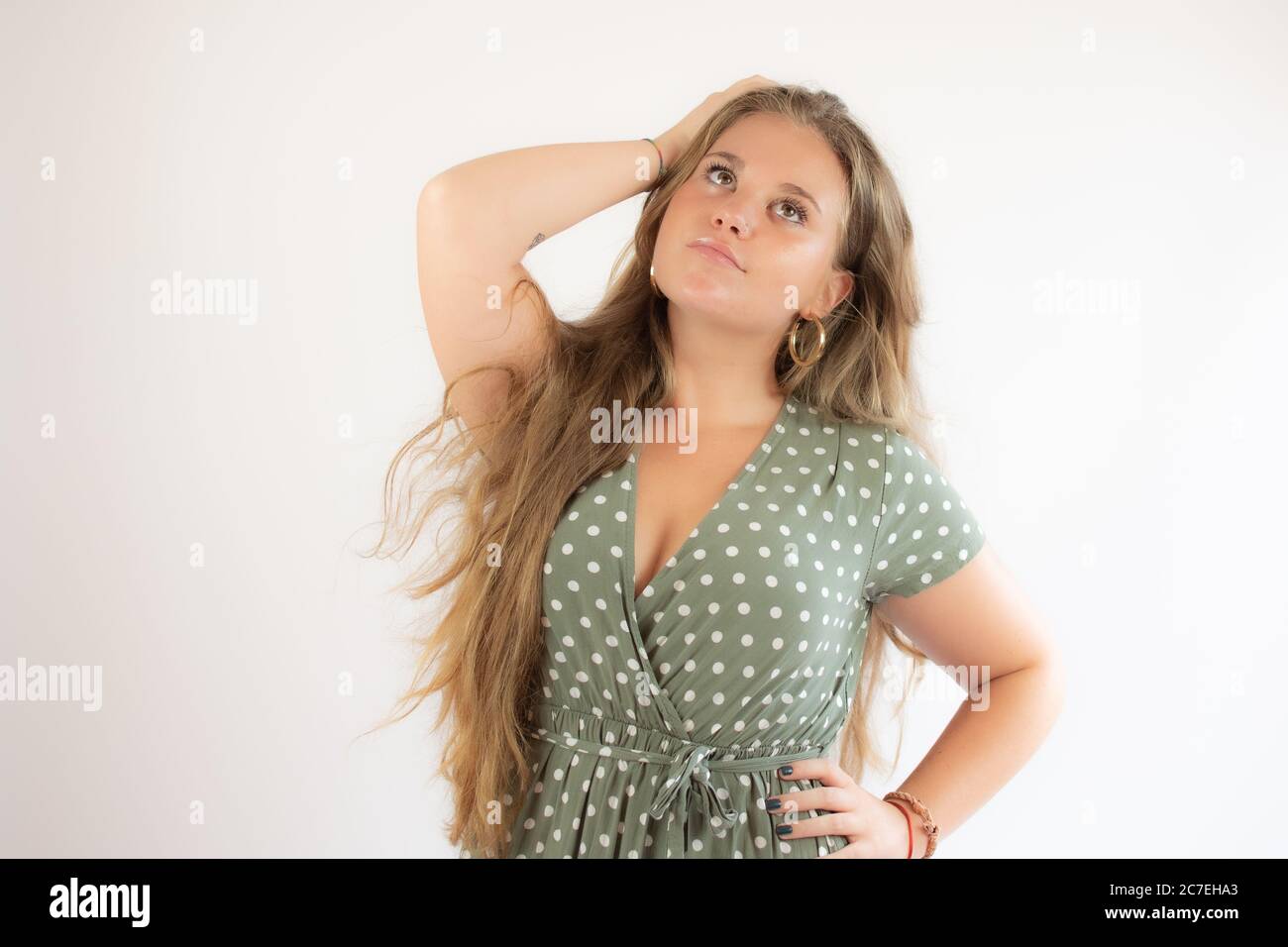 Pretty blonde girl in a green dress with the gesture of concern Stock ...