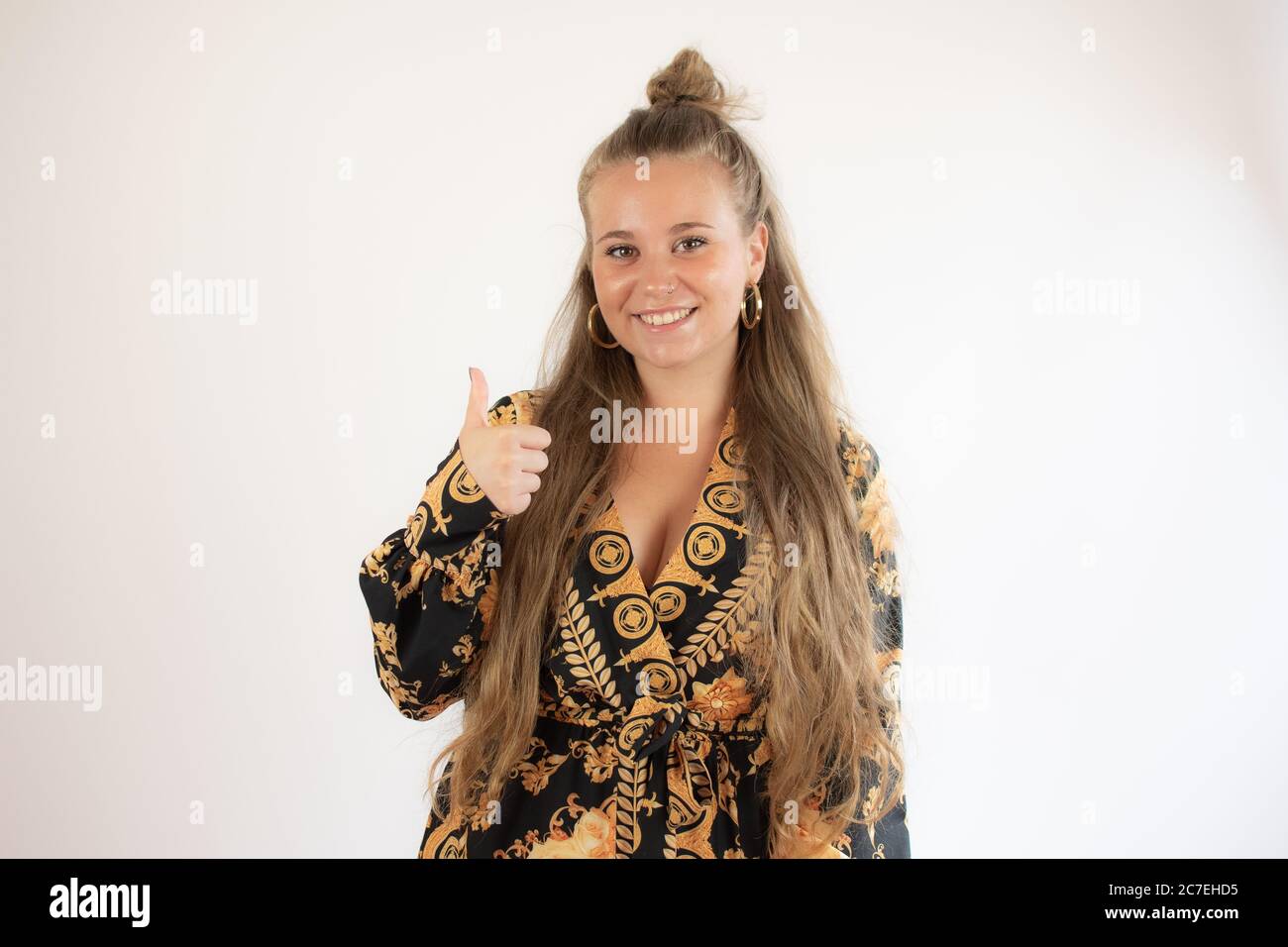 Pretty blonde girl in black gold dress smiling Stock Photo - Alamy