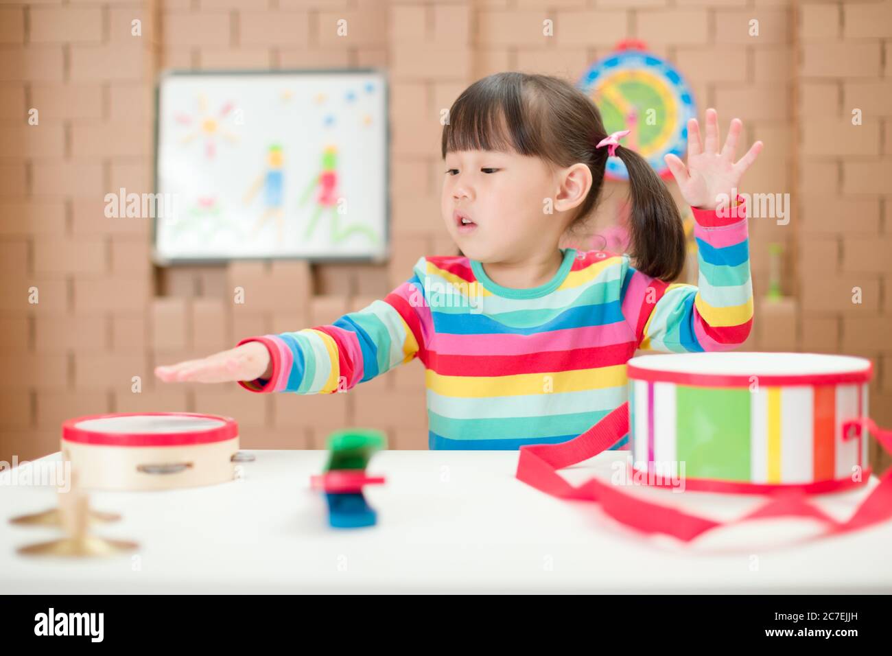 toddler girl play harmonica at home for homeschooling Stock Photo Alamy