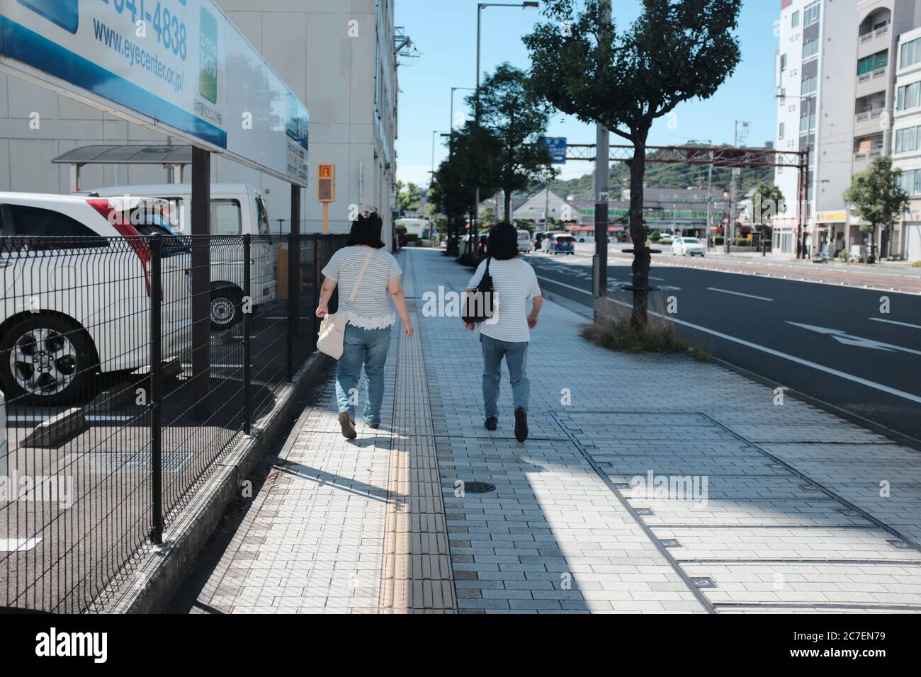 MATSUYAMA, JAPAN - Sep 23, 2019: A horizontal shot of two friends wearing matching outfits walking on the sidewalk Stock Photo