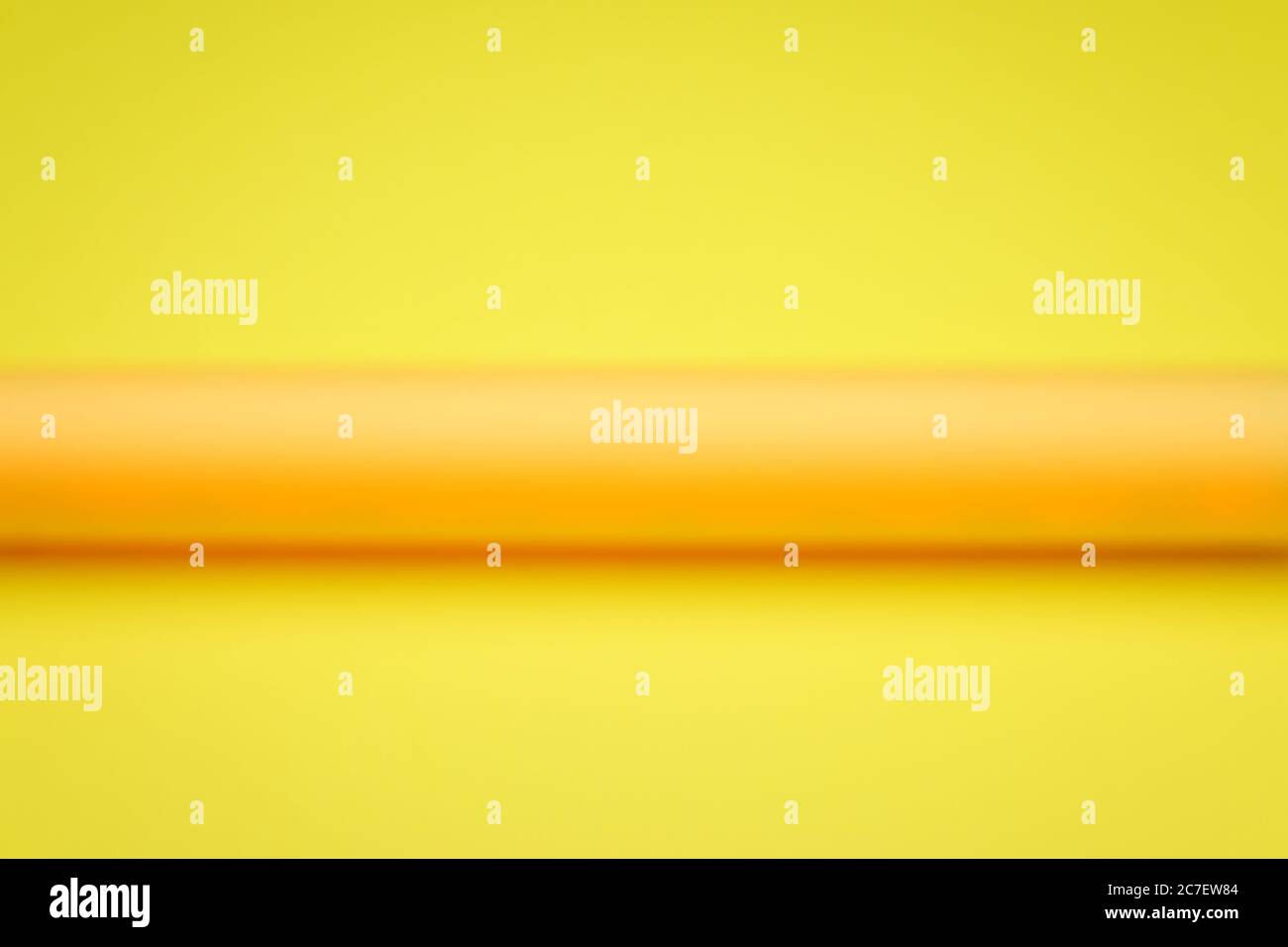 A Blurred Orange Tube, Showing the Horizontal Cylinder Lines Against a Yellow Background. Stock Photo