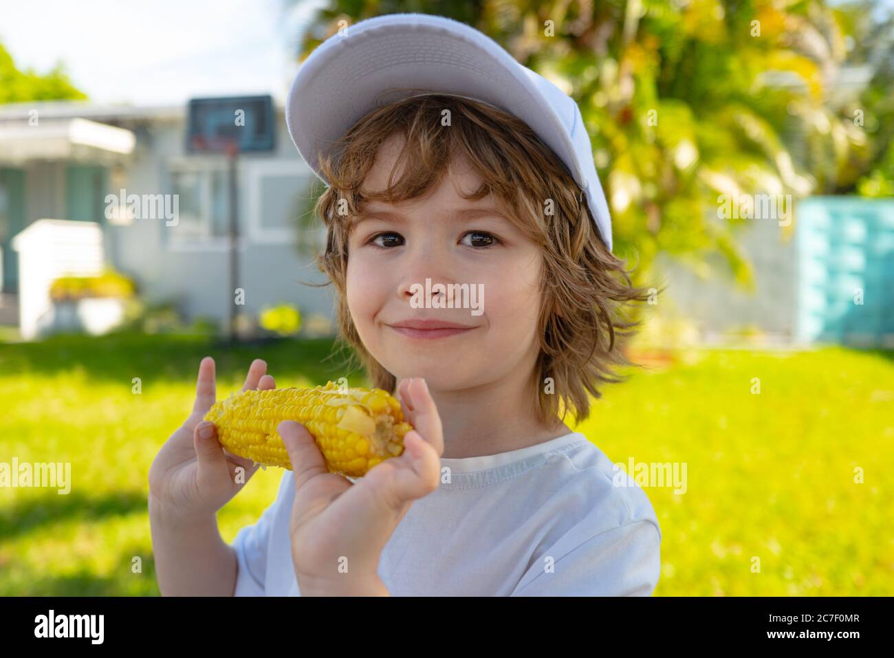 Food for kids. Kids eating corn. Children with vegetables. Kids eating