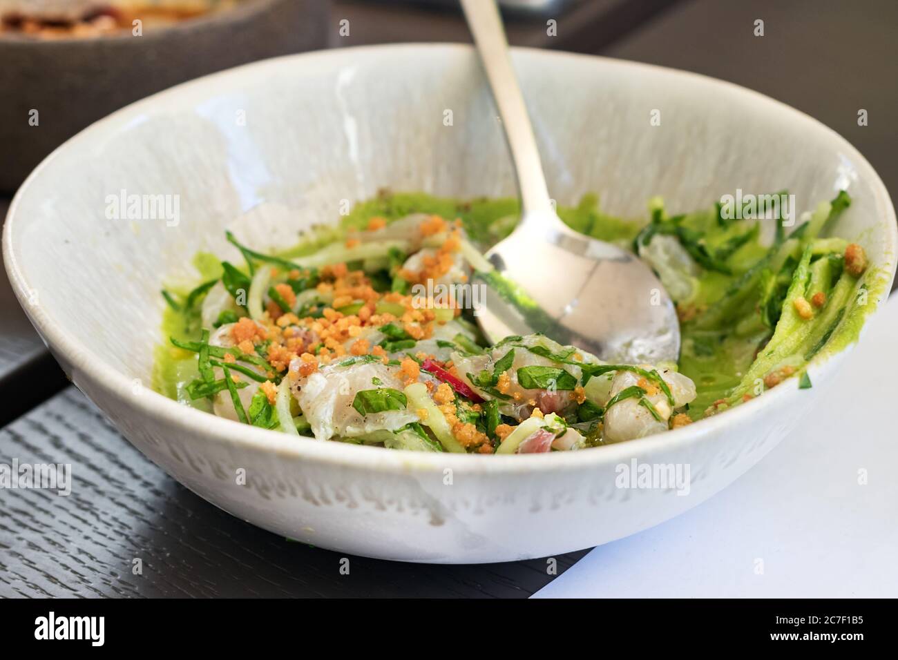 Ceviche Fricasee with green sauce and vegetables. Greek and Peruvian cuisine fusion Stock Photo