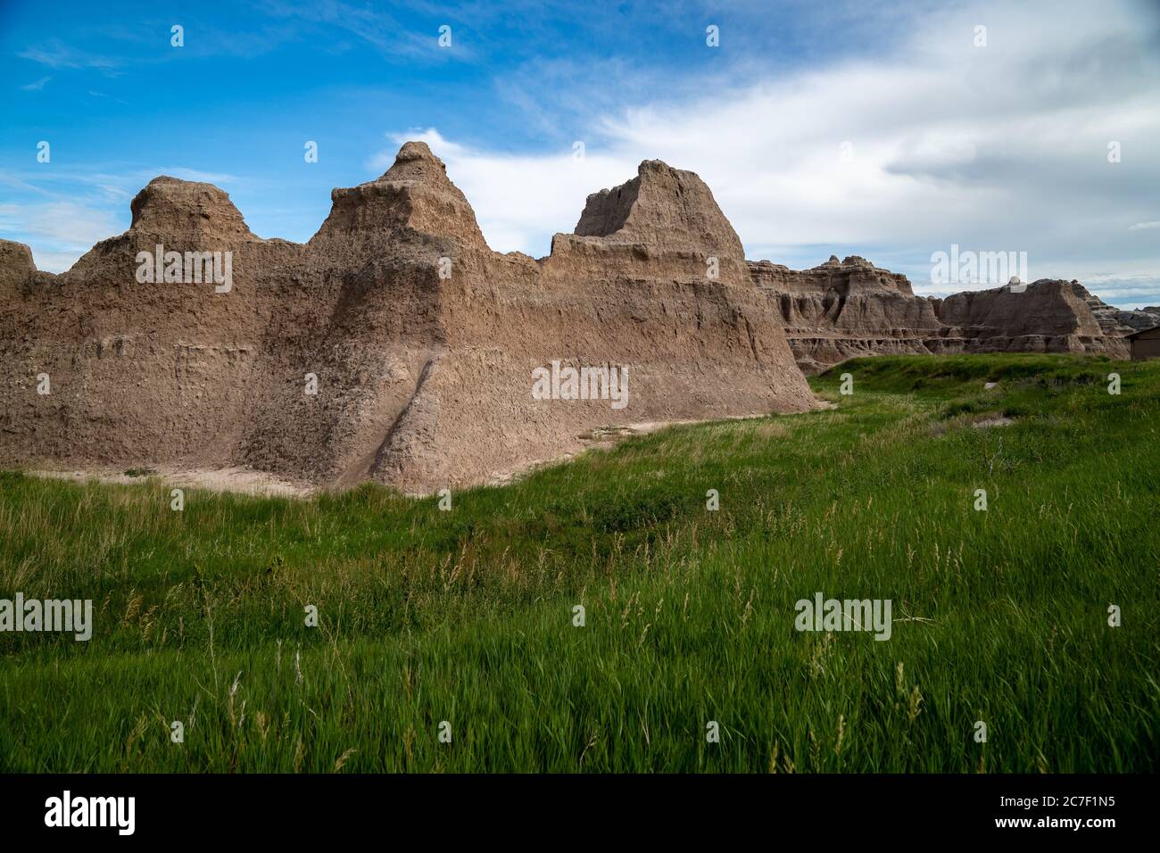 The Notch, Door and Window area of Badlands National Park, with green grass in foreground. South Dakota, USA Stock Photo