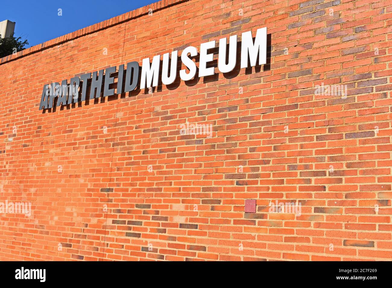A red brick wall with a sign for the Apartheid Museum in Johannesburg, South Africa. Stock Photo
