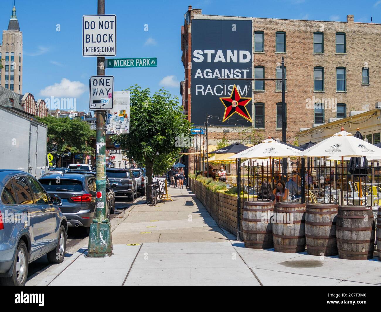 View north on Damen Avenue, Wicker Park neighborhood of Chicago. Big Star Restaurant at right. Stand against racism banner on building. Stock Photo