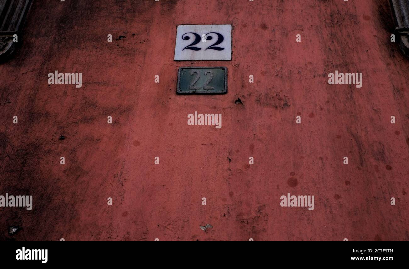 Number 22, twenty-two, two plates on grungy dark wall. Stock Photo