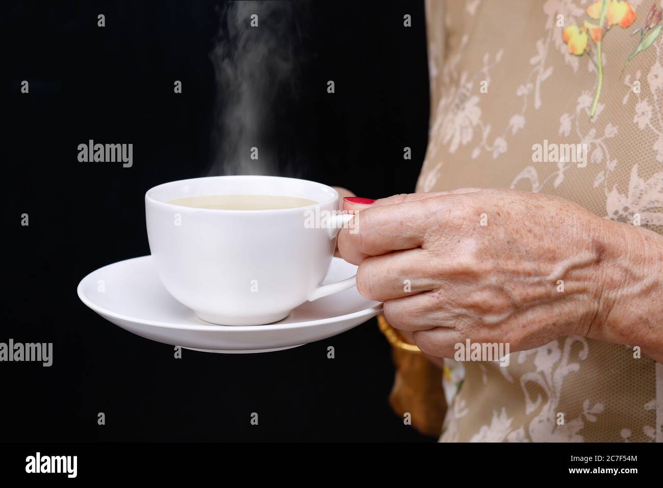 Senior woman holding a coffee cup . Stock Photo