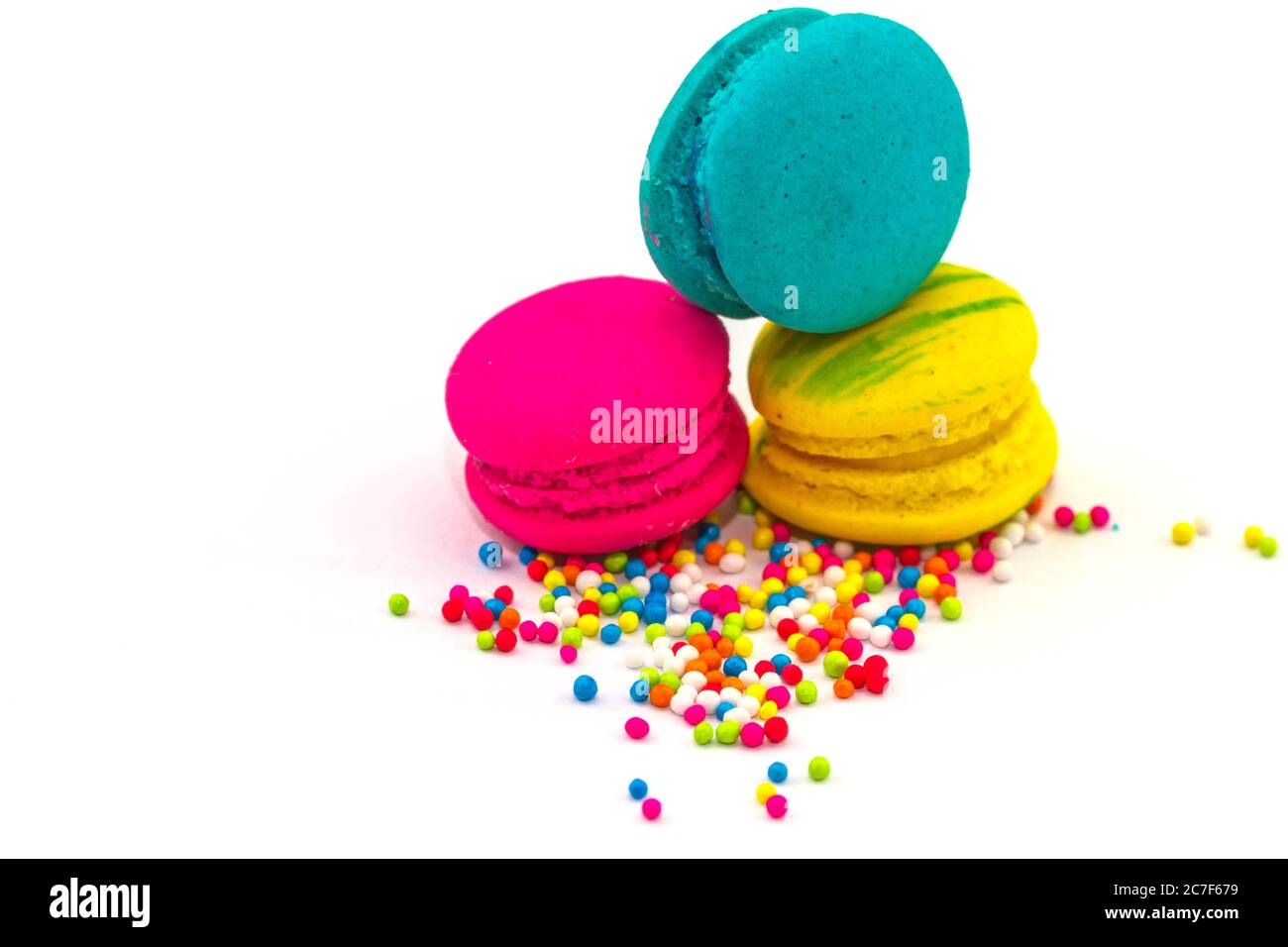 Sweet and colourful french macaroons or macaron  isolated on white backgroud with sugar topping. Stock Photo