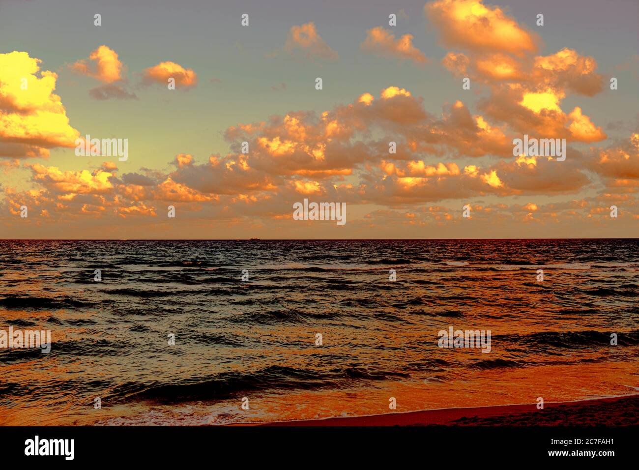 Beautiful scenery of the sunset reflecting on the sea under the golden ...