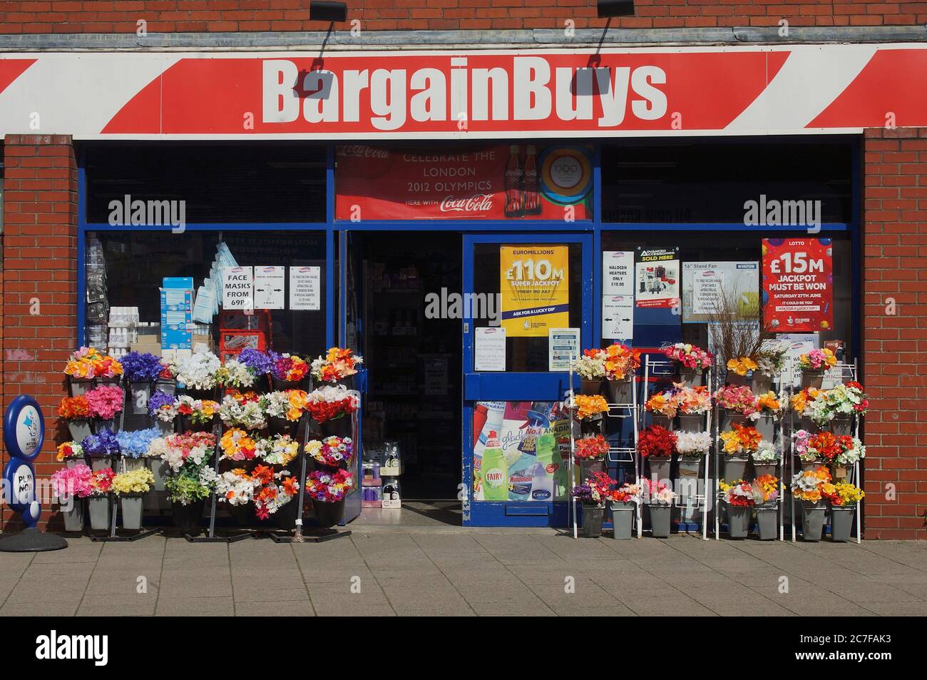 Bargain Buys (formally Wise Owl) shop entrance displaying bunches of colourful flowers outside Stock Photo