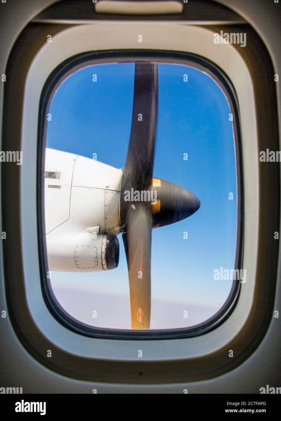 View through an airplane window of the propeller engine Stock Photo