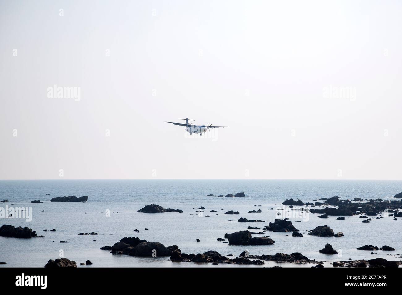 Airplane coming in for a landing flies low over Ngapali Beach to Thandwe Airport in the Rakhine State, Myanmar Stock Photo