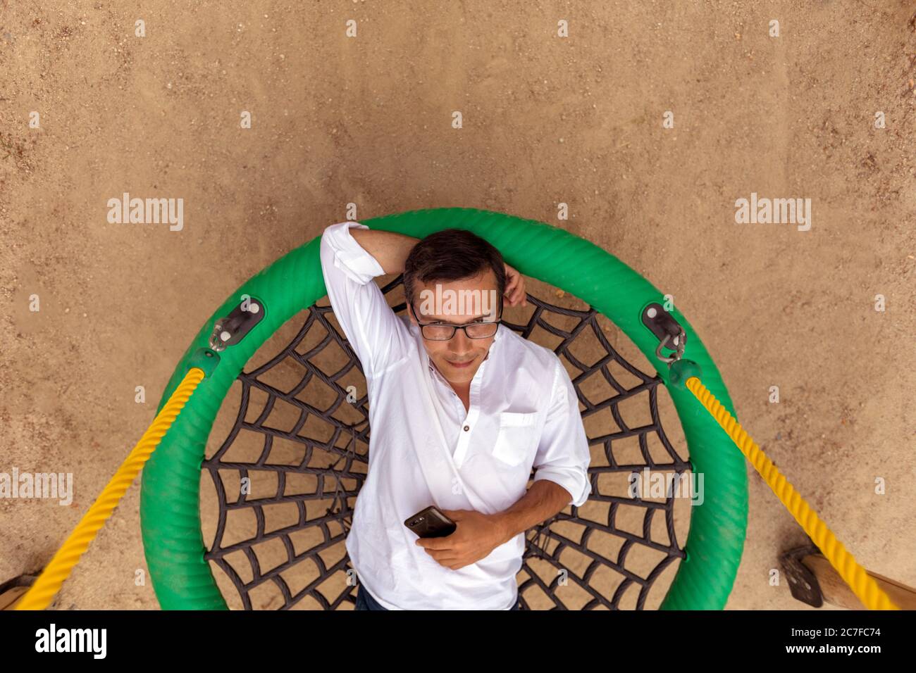 Carefree man on swing in park Stock Photo