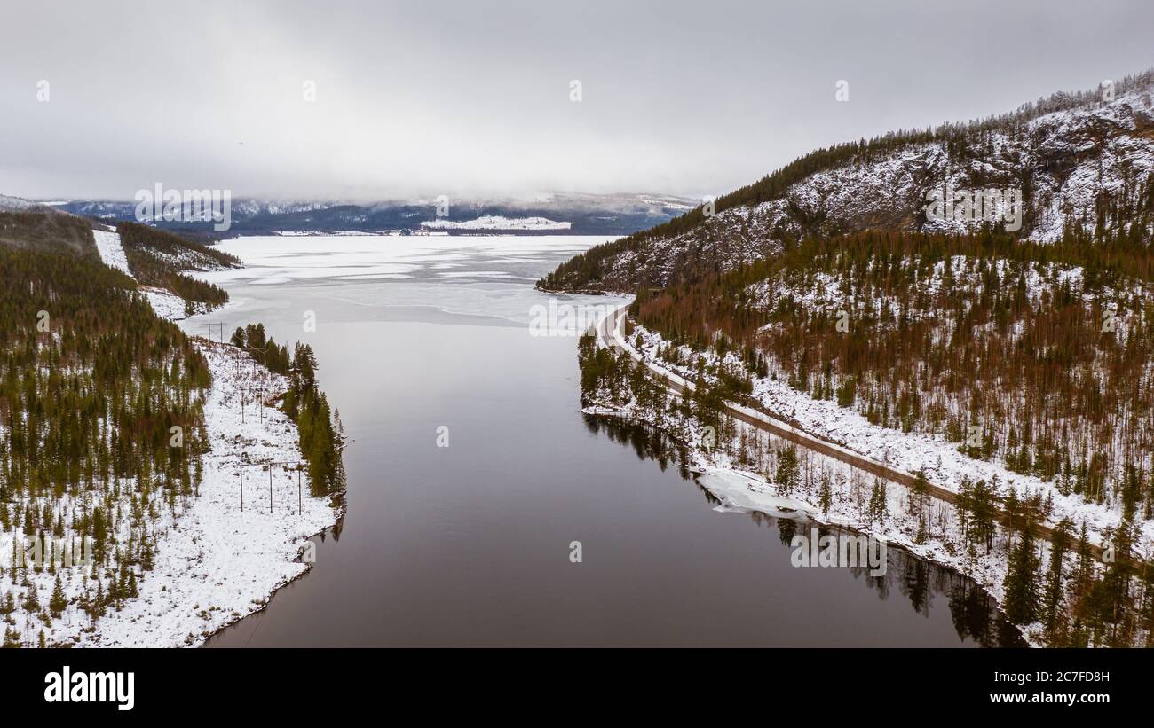 Scenery of a frozen lake surrounded by snowy mountains in Lapland ...