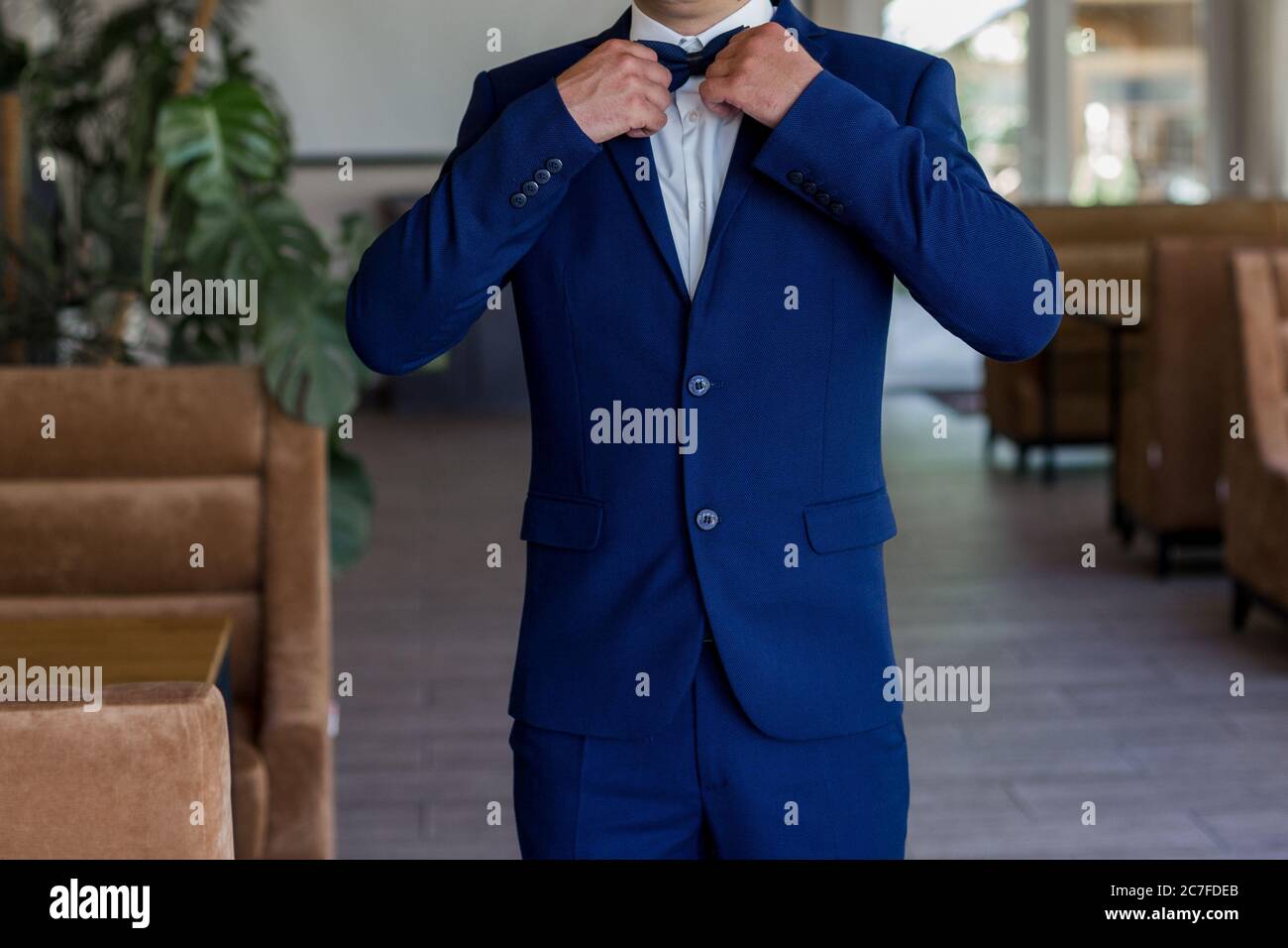 a man in blue suit and bow tie Stock Photo - Alamy
