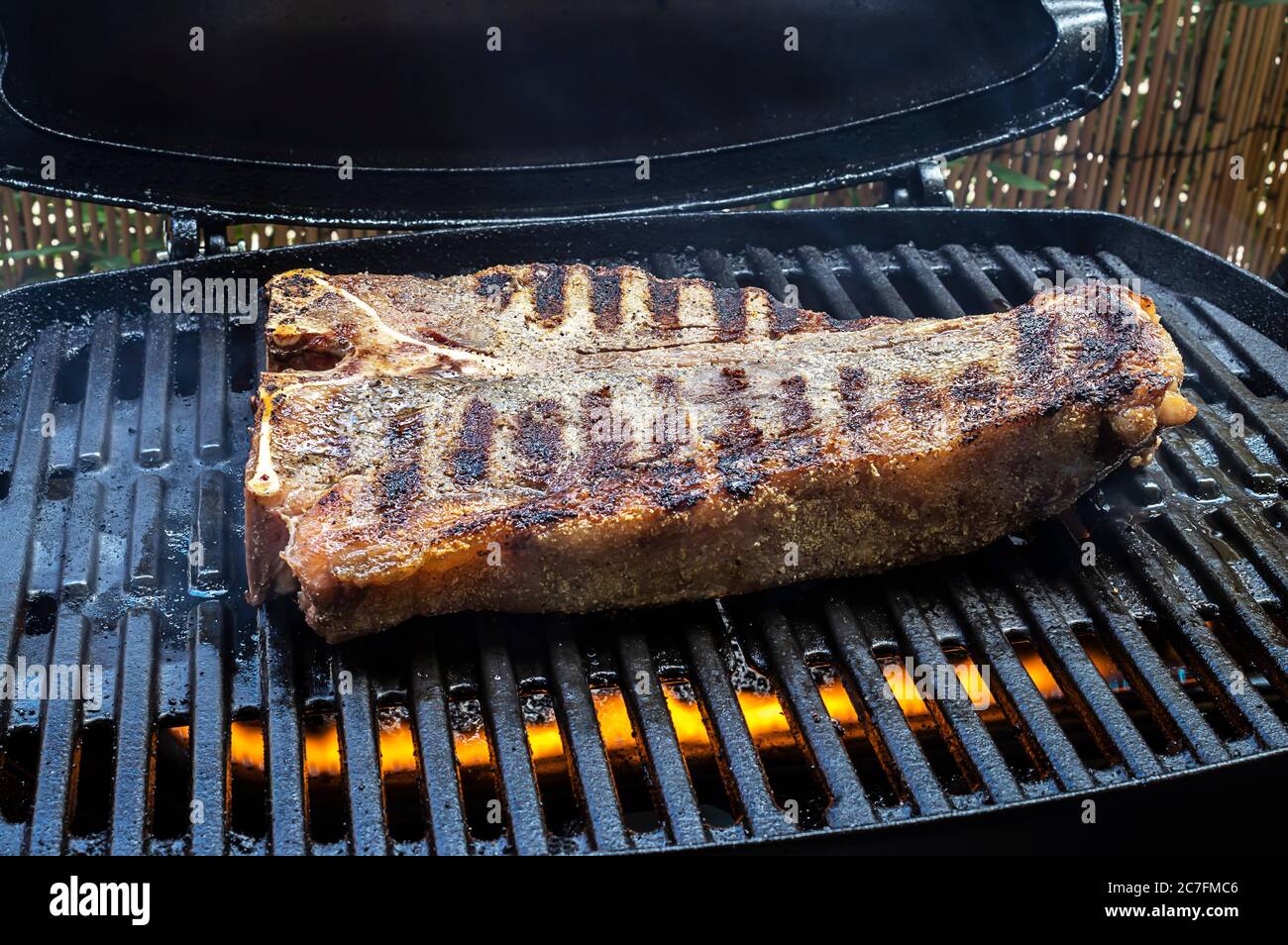 Cooking thick tbone steak on barbecue grill Stock Photo Alamy