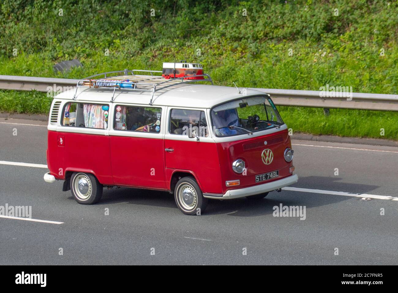 1972 70s Type 2 Red white VW Volkswagen LCV Motor Caravan;Touring Caravans and Motorhomes, 70s campervans on Britain's roads, RV leisure vehicle, mini bus family holidays, caravanette vacations, caravan holiday, van conversions, autohome, life on the road Stock Photo