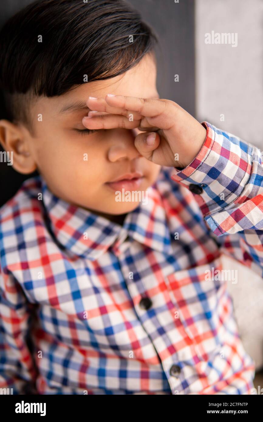 Portrait of sick little boy feeling headache. Stock Photo