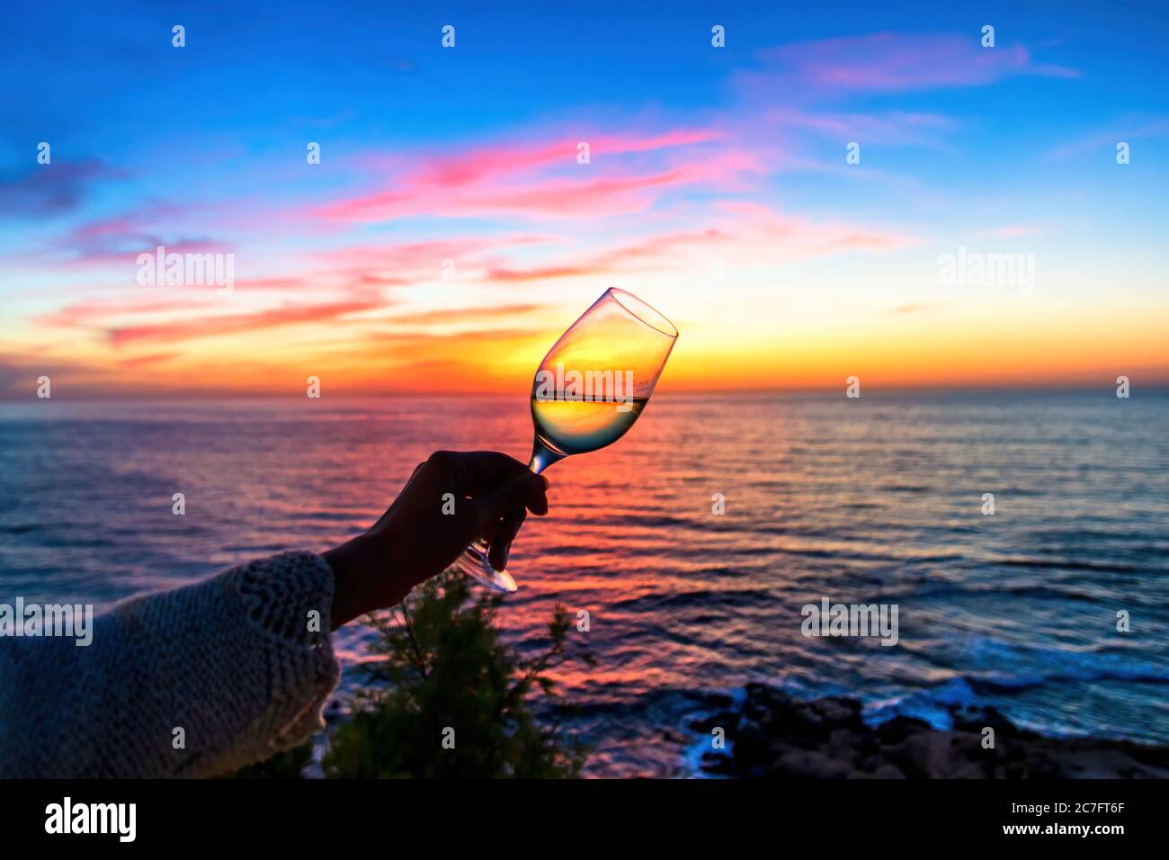 A glass of white wine at sunset resumes the movement of the sea