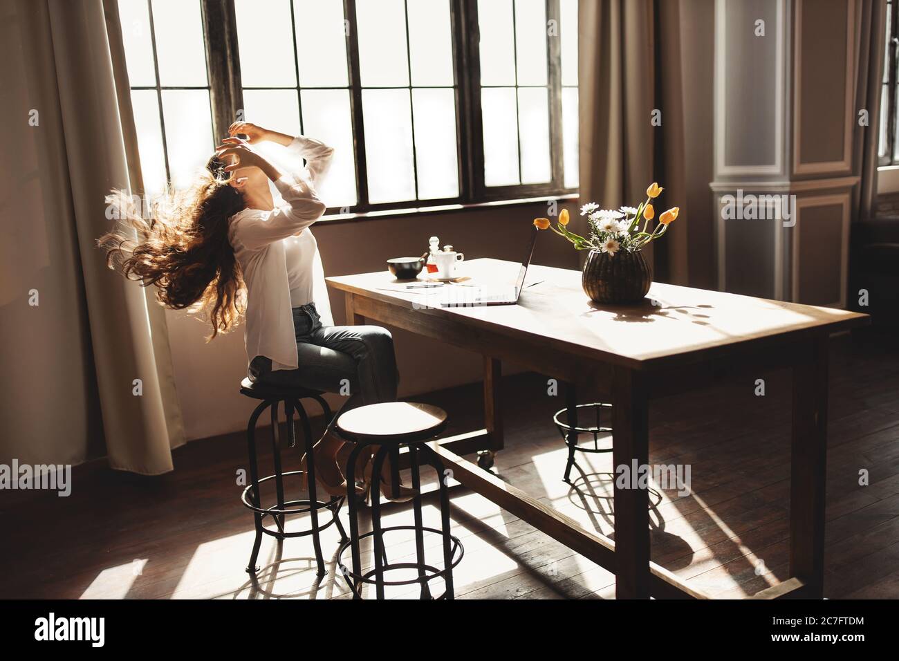 Young business woman working on laptop with phone from home  Stock Photo