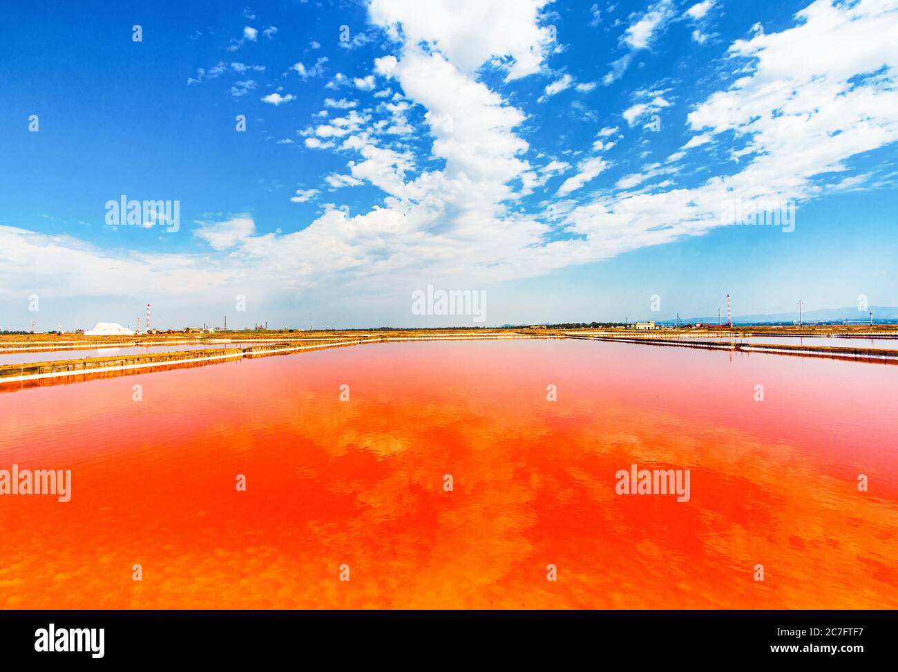 Lago di sale rosso con riflesso cielo nuvoloso, presso le saline Conti Vecchi, uno spettacolo della natura Stock Photo