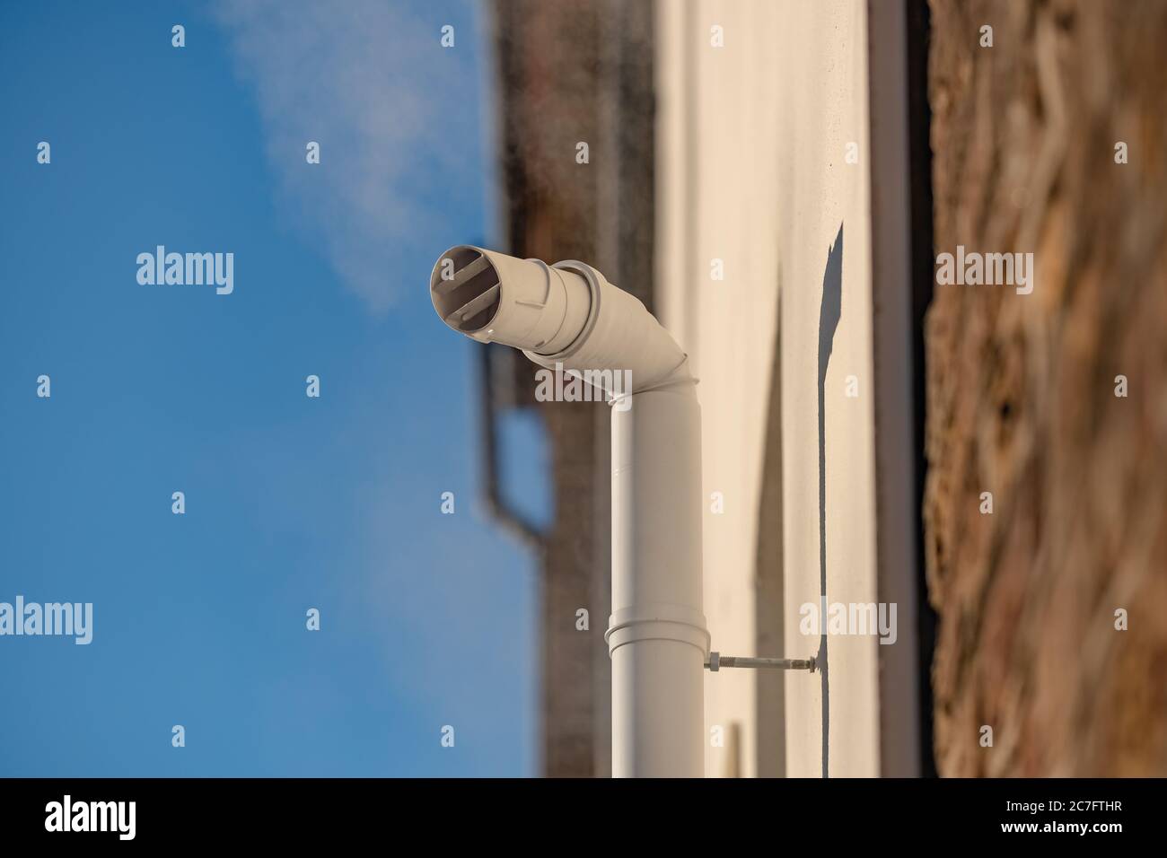 Detailed view of a newly installed steam ventilation pipe attached to a condenser boiler within