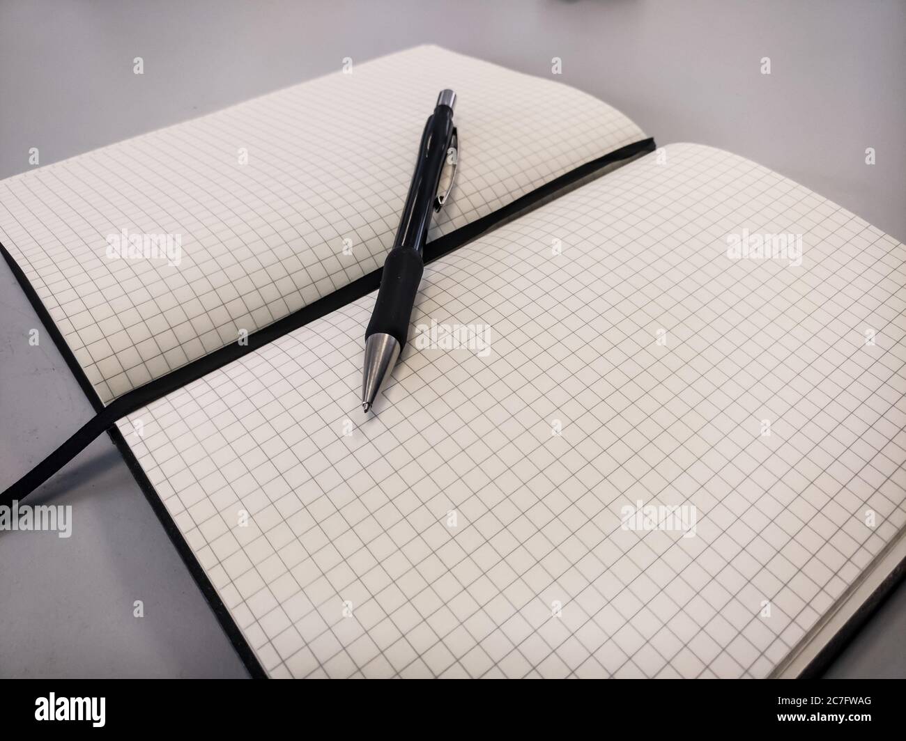 Black pen on a square ruled notebook against a white background Stock ...