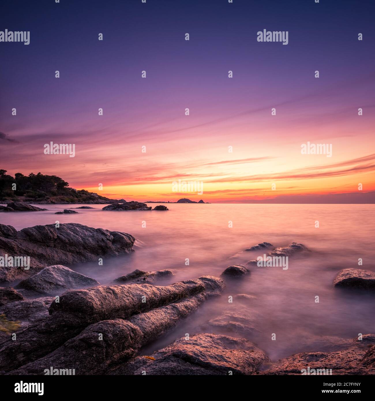 Afterglow of sunset over La Pietra, the red rock of Ile Rousse, in the ...