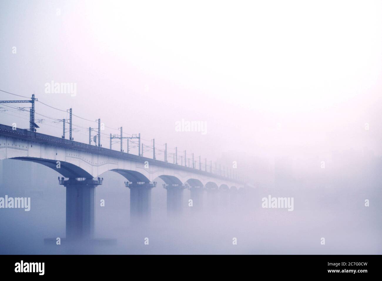 Railway arches bridge disappearing into the fog Stock Photo