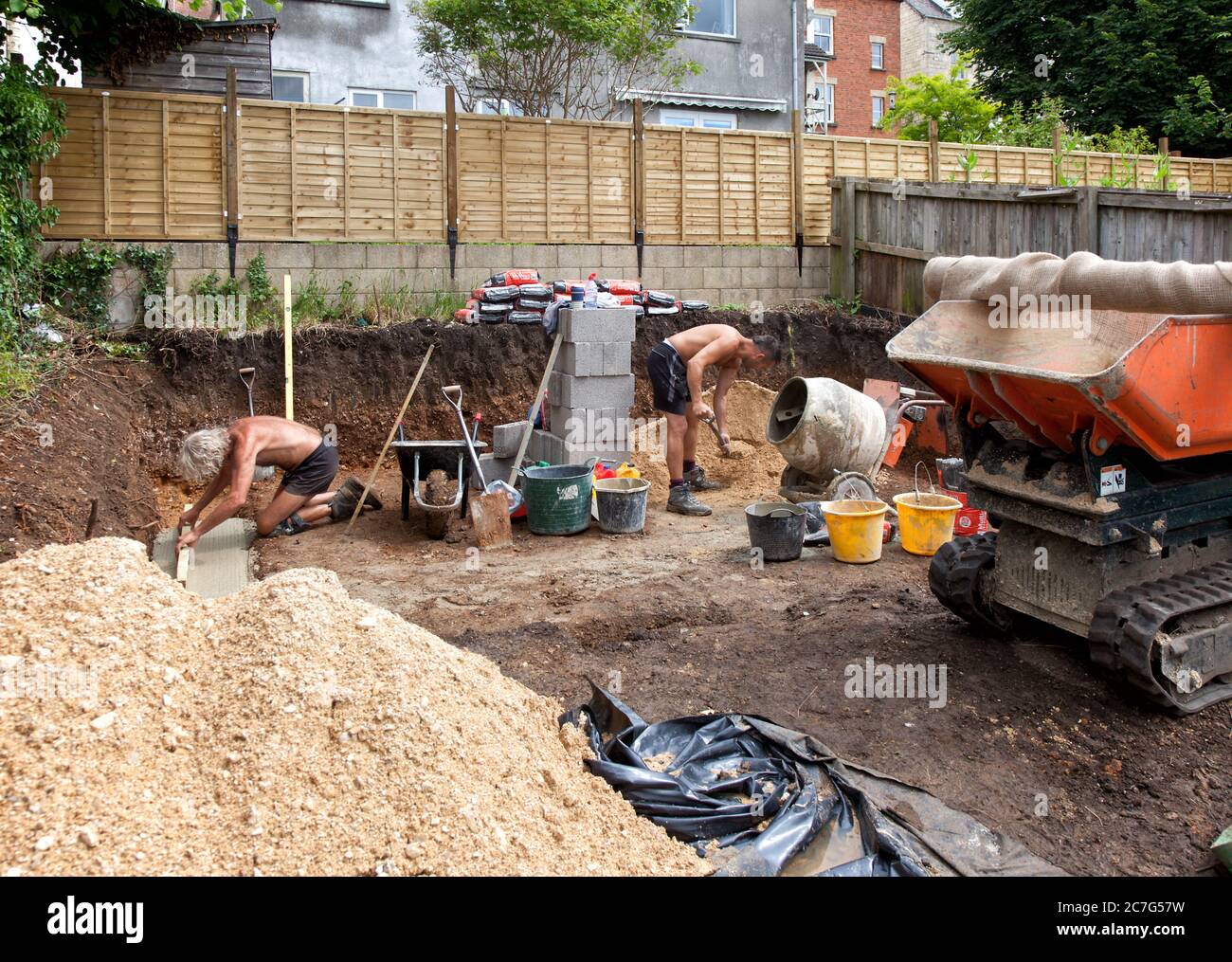 Two builders preparing foundations for garden studio Stock Photo