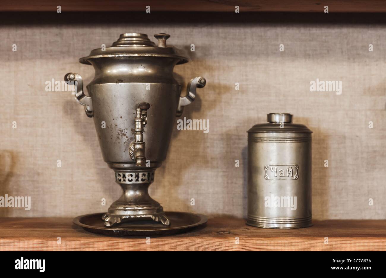 Traditional vintage Russian Samovar, a metal container used to heat and boil water for tea is standing near metal jar. Russian text on the container m Stock Photo