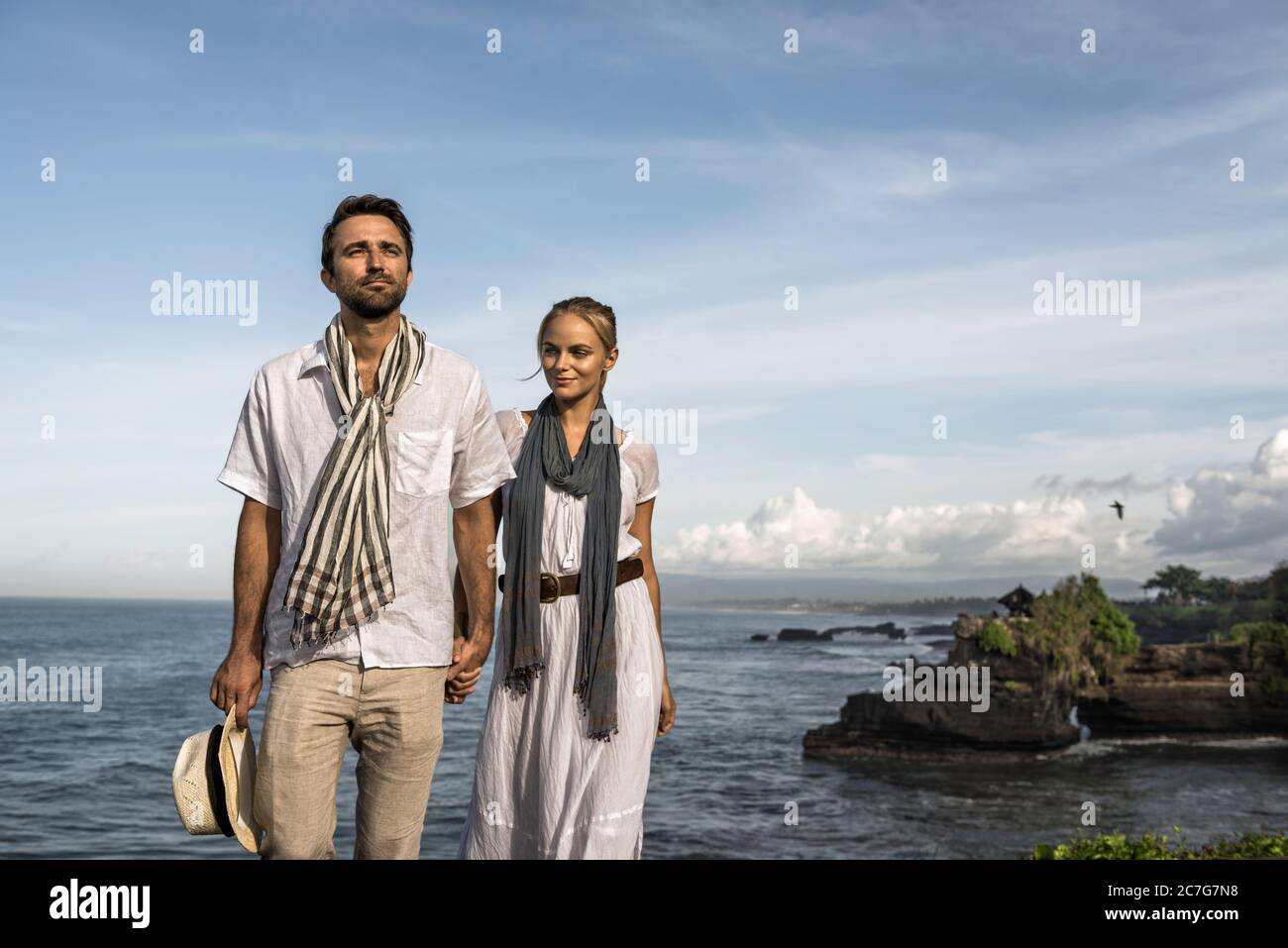 Asia, Indonesia, Bali, young Caucasian couple, wearing smart casual clothing, enjoying a visit to the famous Hindu temple Tanalot, which is one of the Stock Photo