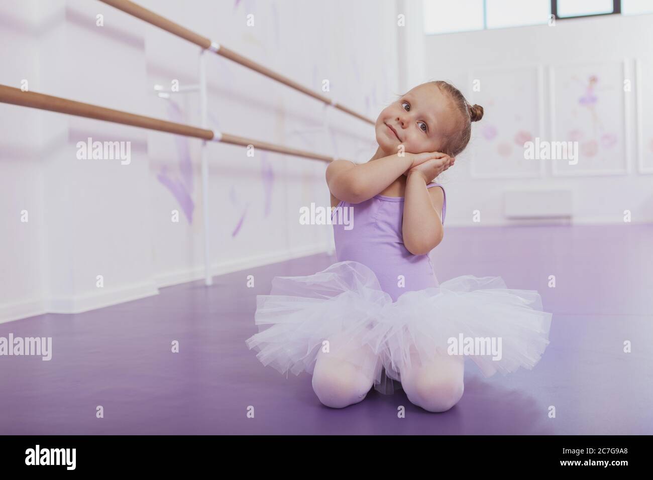Cute little ballerina dancing at ballet school, copy space. Adorable little girl in ballet outfit practicing at dance class. Children, kids developmen Stock Photo