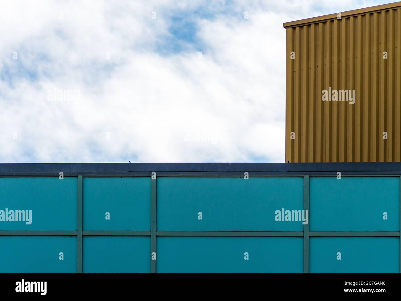 Low angle shot of the blue facade of a glass building under the cloudy ...