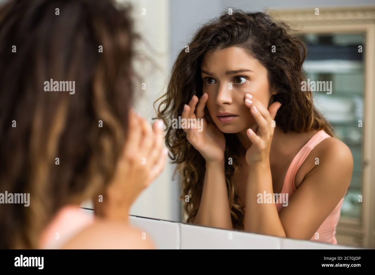 Tired woman looking her eye bags in the bathroom Stock Photo Alamy