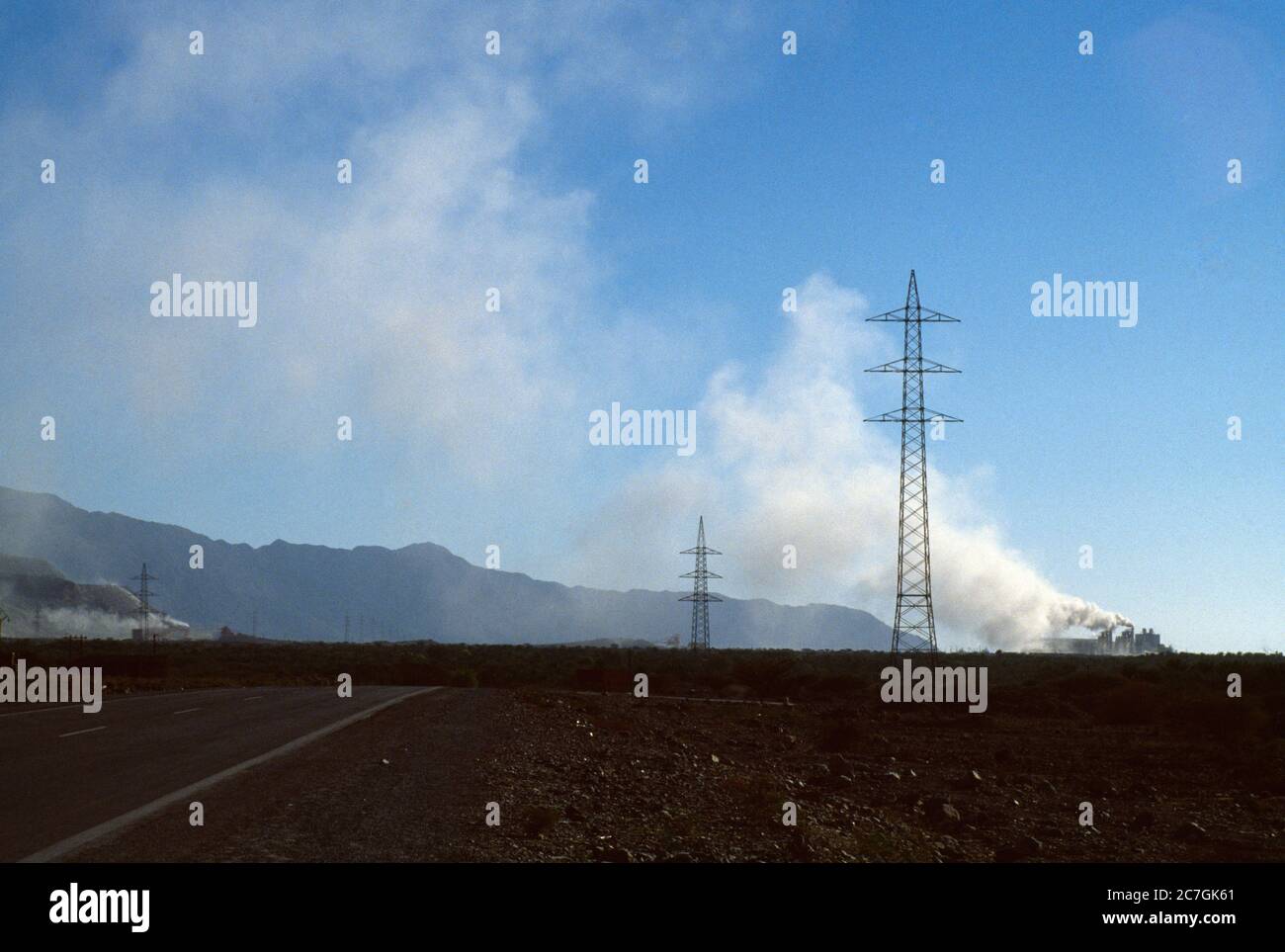 Dubai UAE Electricity Pylons and Factories in the distance in Scrub Desert Stock Photo