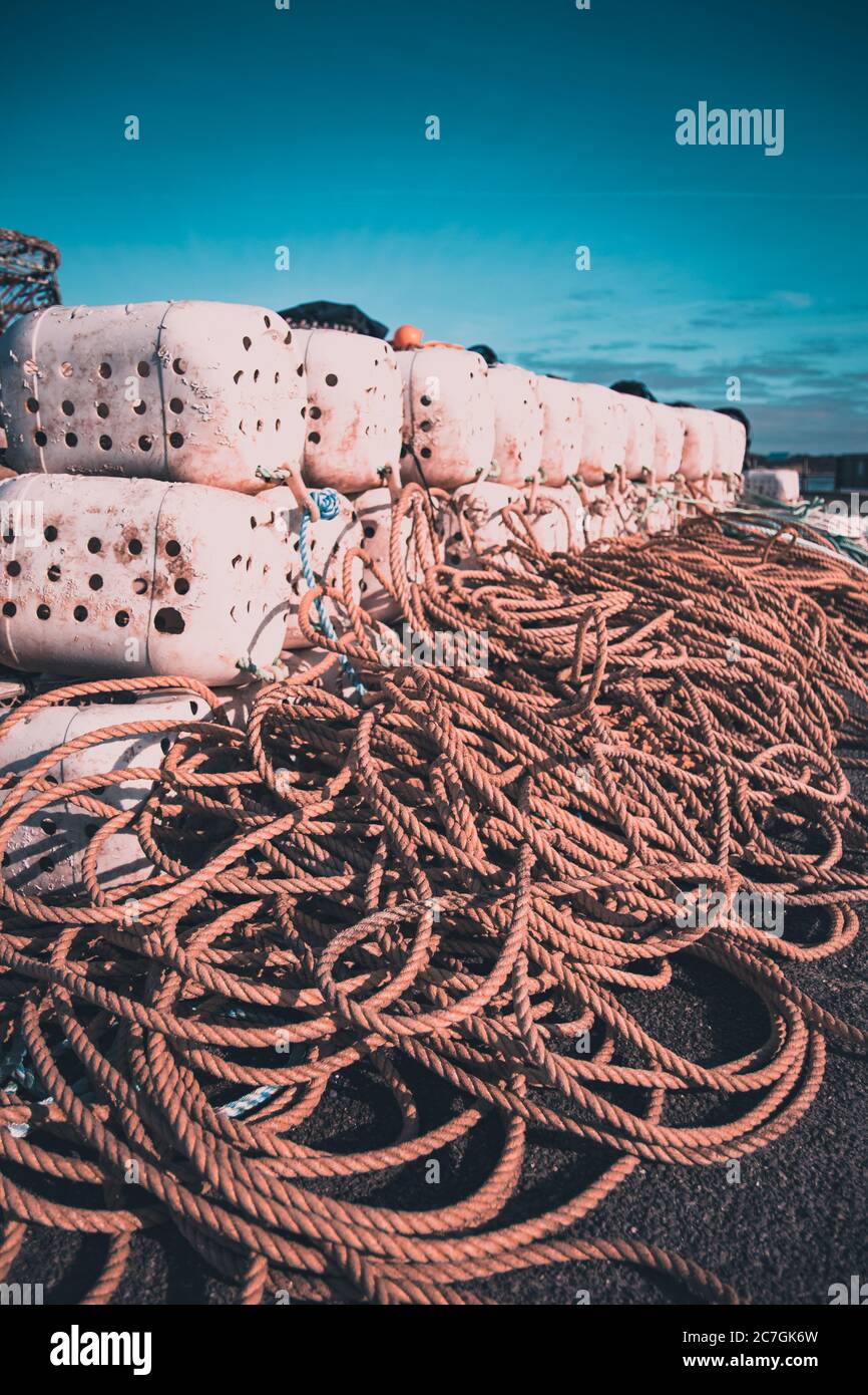 Fishing pots or traps stacked on a dock or quay Stock Photo