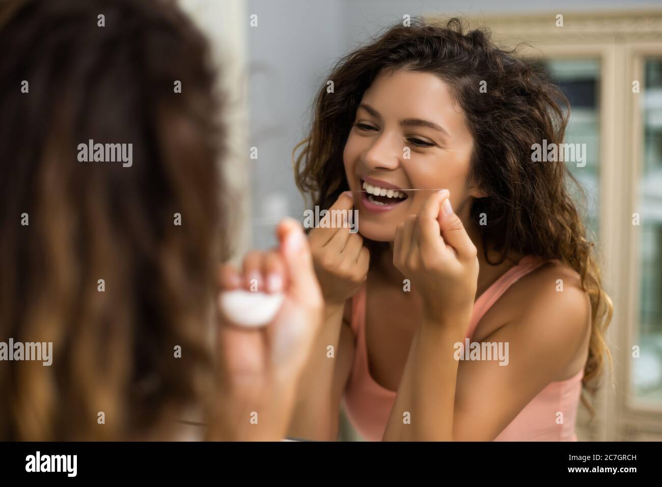 Beautiful woman using dental floss in the bathroom Stock Photo Alamy