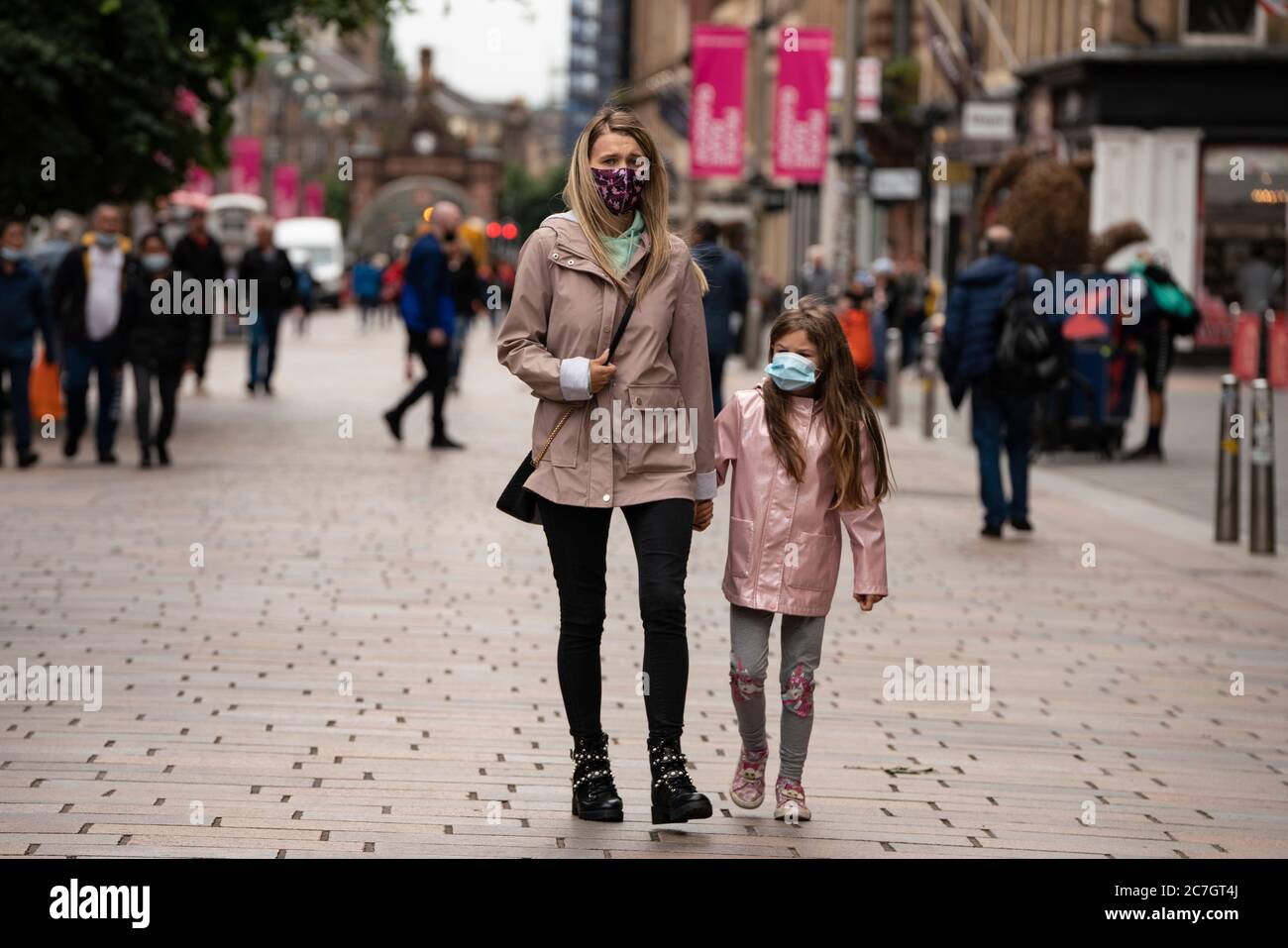 Glasgow, Scotland, UK. 17 July, 2020.  Images from Glasgow city centre as covid-19 restrictions are relaxed and  the public are out and about shopping and at work. Pictured; Mother and daughter walking on Buchanan Street wearing face coverings. Iain Masterton/Alamy Live News Stock Photo