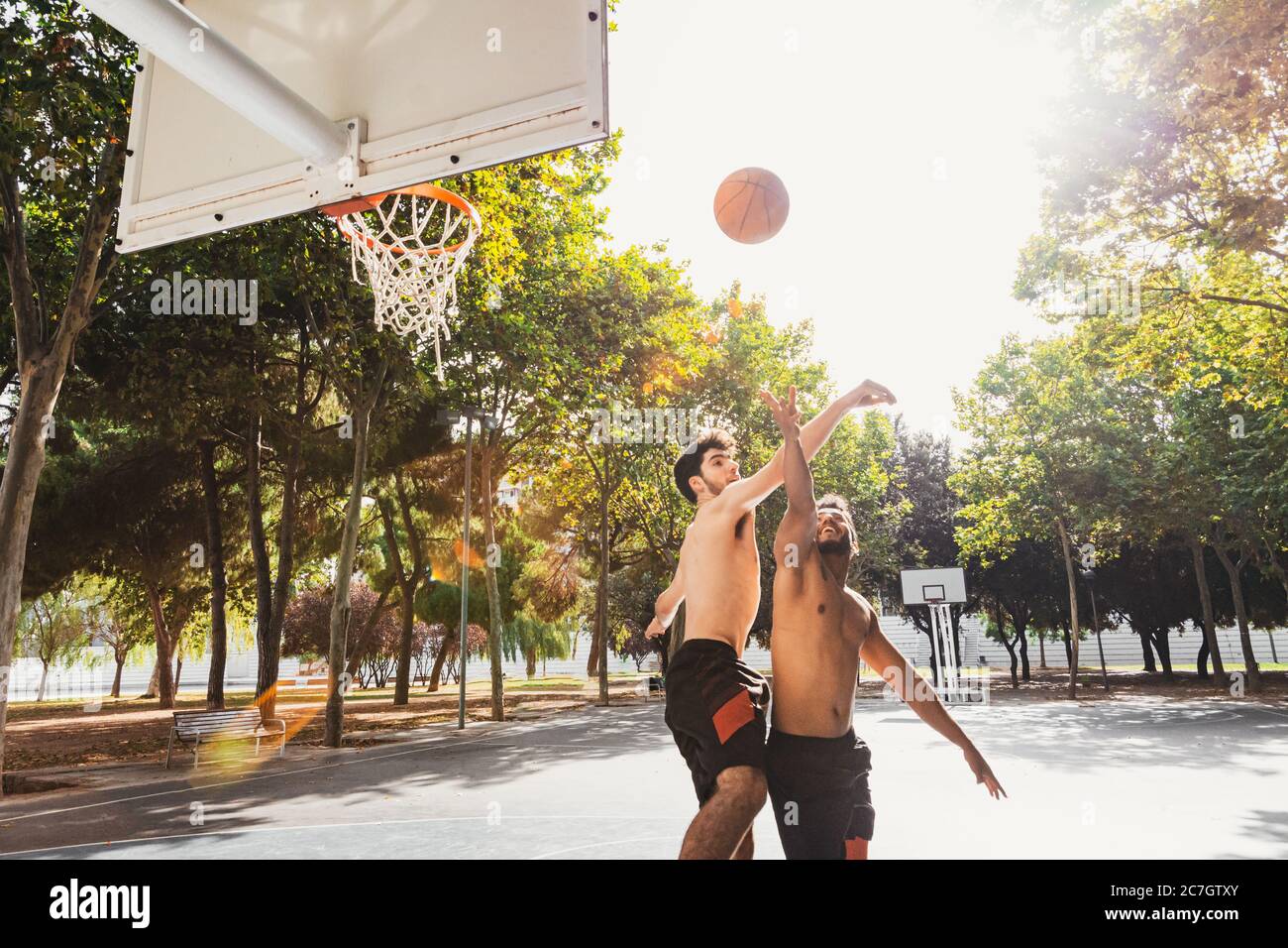 two young men play basketball outdoors Stock Photo Alamy