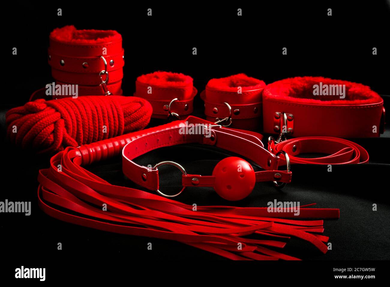 long range sex toys Sexual kink, erotic games and human sexuality concept with complete red sex  toy kit set (ball gag, cuffs, rope, flogger, collar and leash) for BDSM fa  Stock Photo