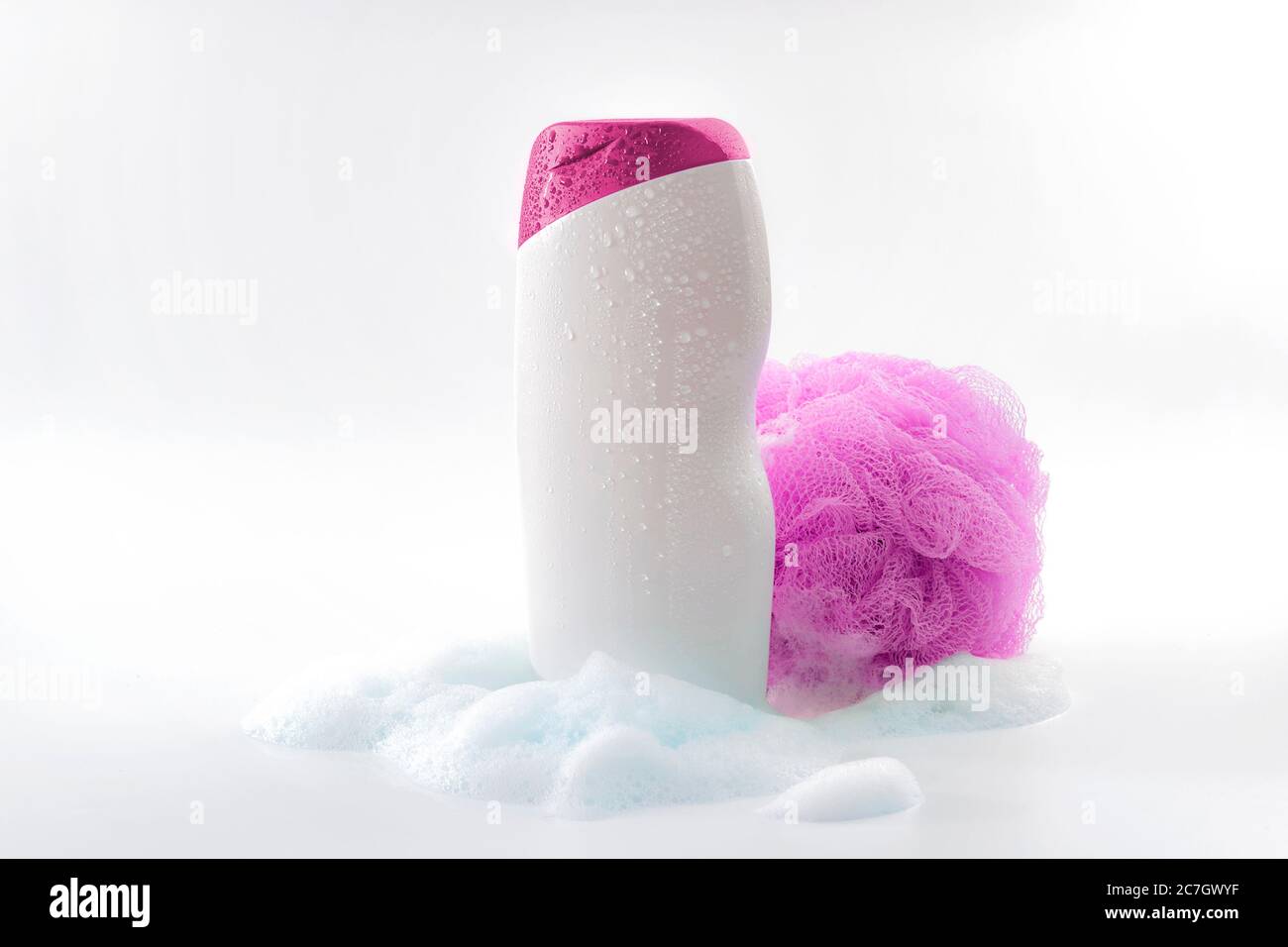 Personal hygiene, daily routine and body care toiletries concept theme with a bottle of shower gel soaked in water drops, bubbles made by soap foam an Stock Photo