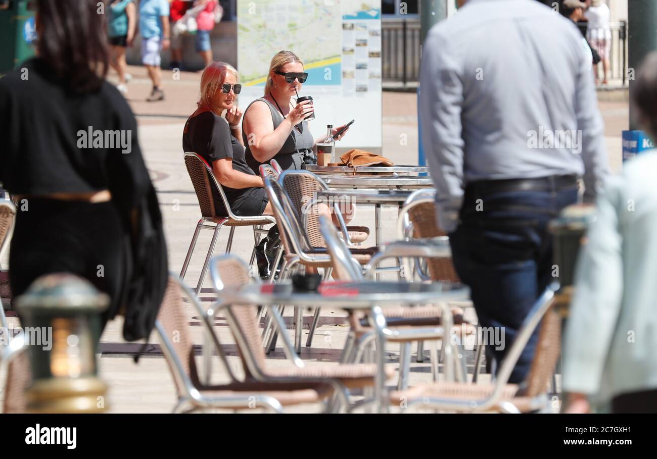 Bournemouth, UK. 17th July 2020.  Two women enjoy their drinks at a cafe in Bournemouth Square, Dorset. credit: Richard Crease/Alamy Live News Stock Photo