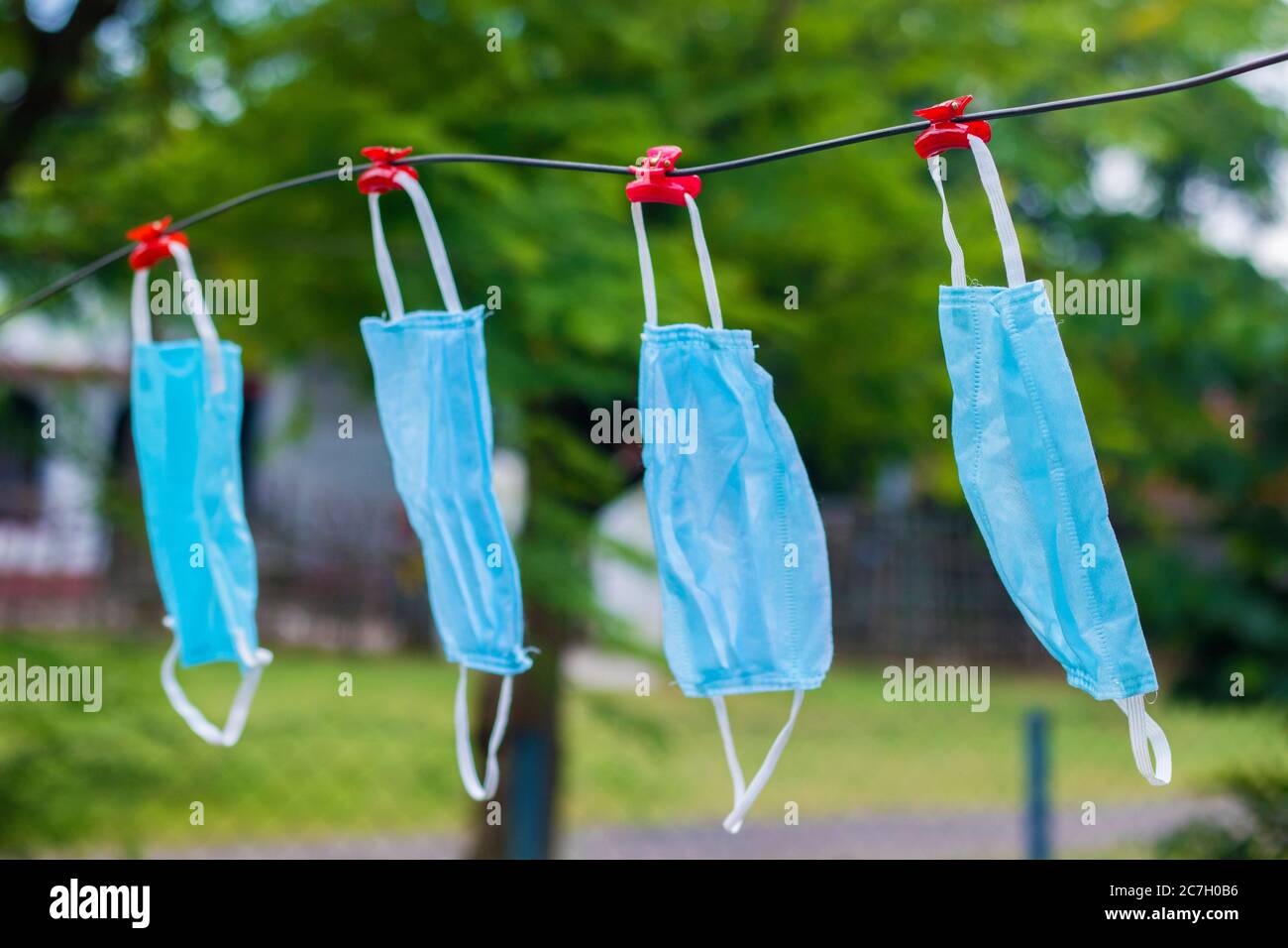 selective focus of face masks hanging on an wire after wash. Stock Photo